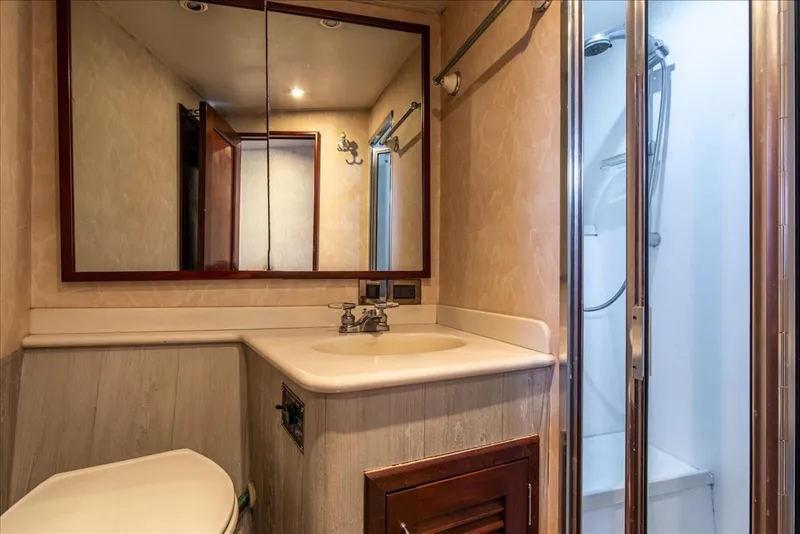 Slide: The Image of 1997 Buddy Davis Sportfisher Convertible bathroom with sink, mirror, and shower. - 26