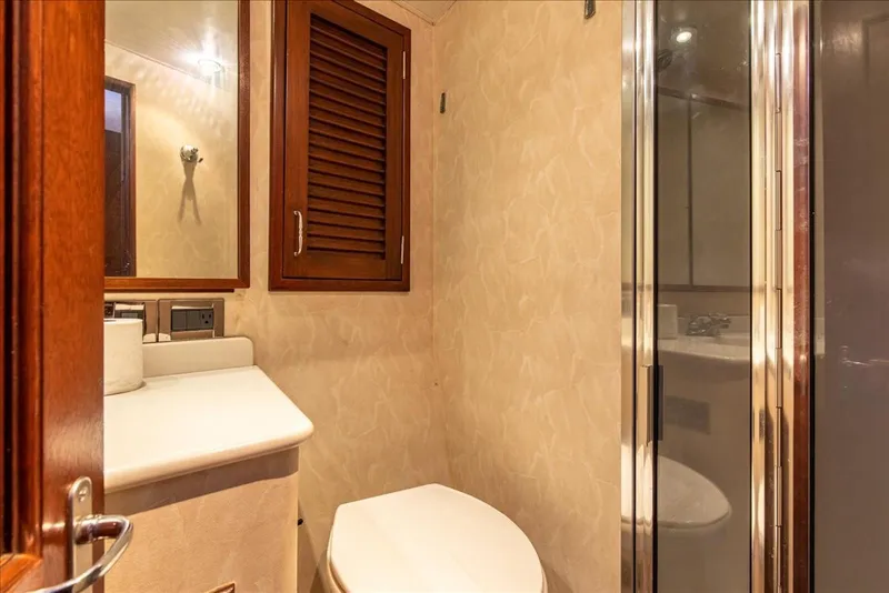 Slide: The Image of Bathroom interior of 1997 Buddy Davis Sportfisher Convertible yacht, featuring wooden accents and modern fixtures. - 27