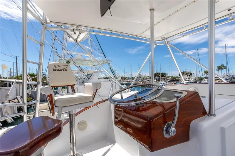 Slide: The Image of 1997 Buddy Davis Sportfisher Convertible helm with wooden console and marina view. - 28