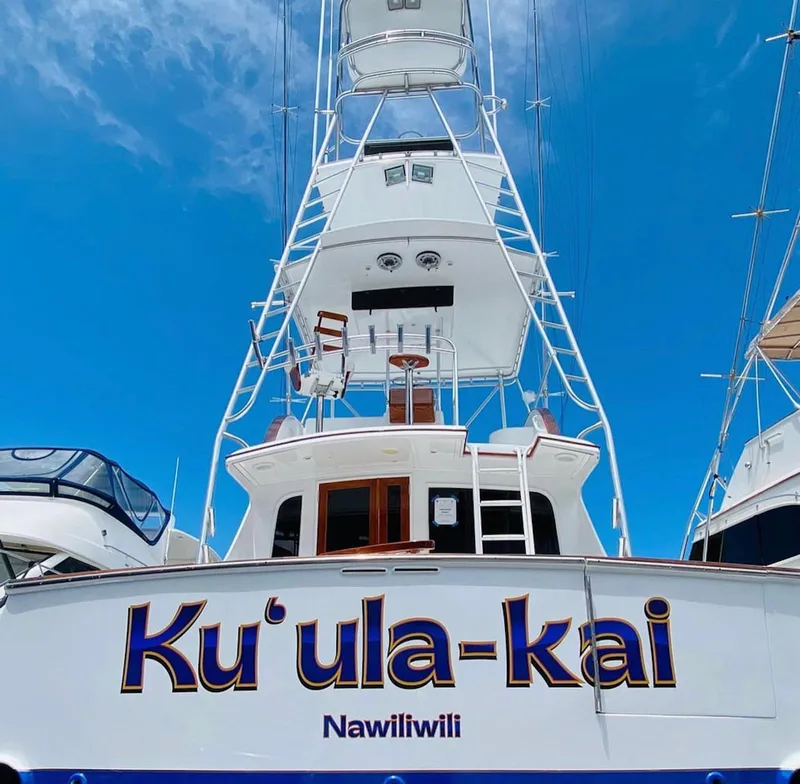 Slide: The Image of 1997 Buddy Davis Sportfisher Convertible boat with "Ku'ula-kai" name, Nawiliwili port, clear sky. - 4