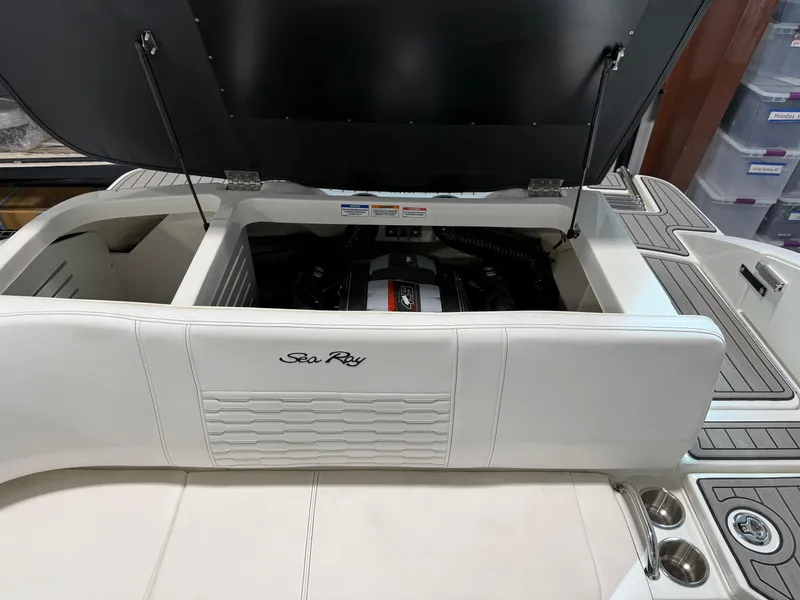Slide: The Image of 2023 Sea Ray SPX 210 boat engine compartment with open hatch, showcasing interior details. - 14