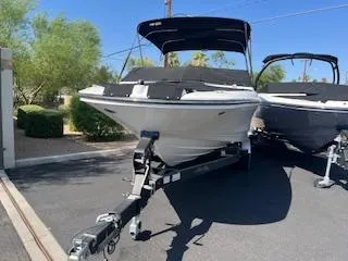 Slide: The Image of 2023 Sea Ray SPX 210 boat on a trailer, parked outdoors. - 18