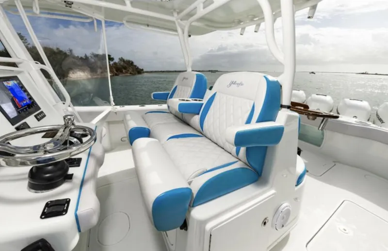 Slide: The Image of 2018 Yellowfin 39 boat interior with blue and white seating, steering wheel, and ocean view. - 17