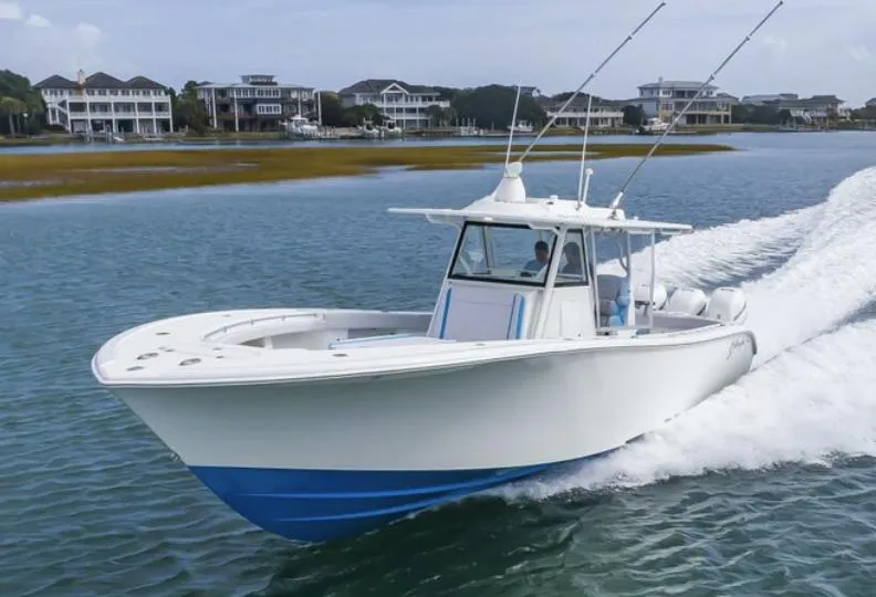 Slide: The Image of 2018 Yellowfin 39 boat cruising on water near coastal homes. - 5