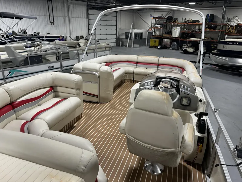 Slide: The Image of 2007 Bennington 2275 RL pontoon boat interior with white and red seating in a storage facility. - 6
