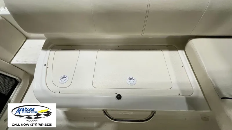 Slide: The Image of 2019 Bayliner 190 Deck Boat interior storage compartment with Marine Center contact information. - 14