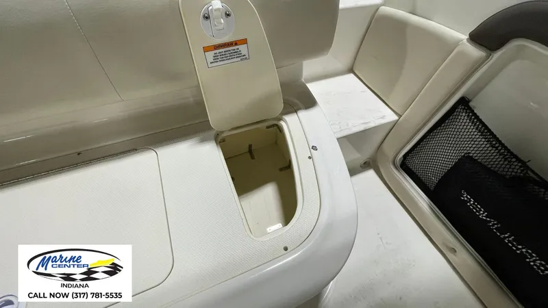 Slide: The Image of 2019 Bayliner 190 Deck Boat interior storage compartment with open hatch and seating area. - 4