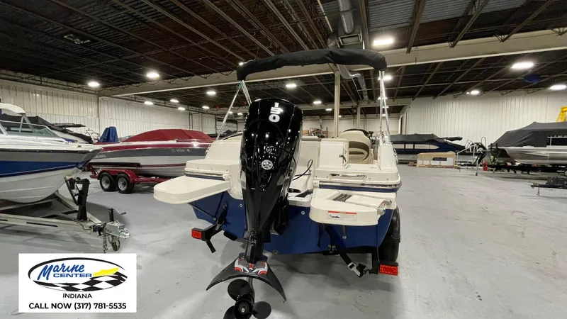 Slide: The Image of 2019 Bayliner 190 Deck Boat in showroom, featuring powerful outboard motor. - 8