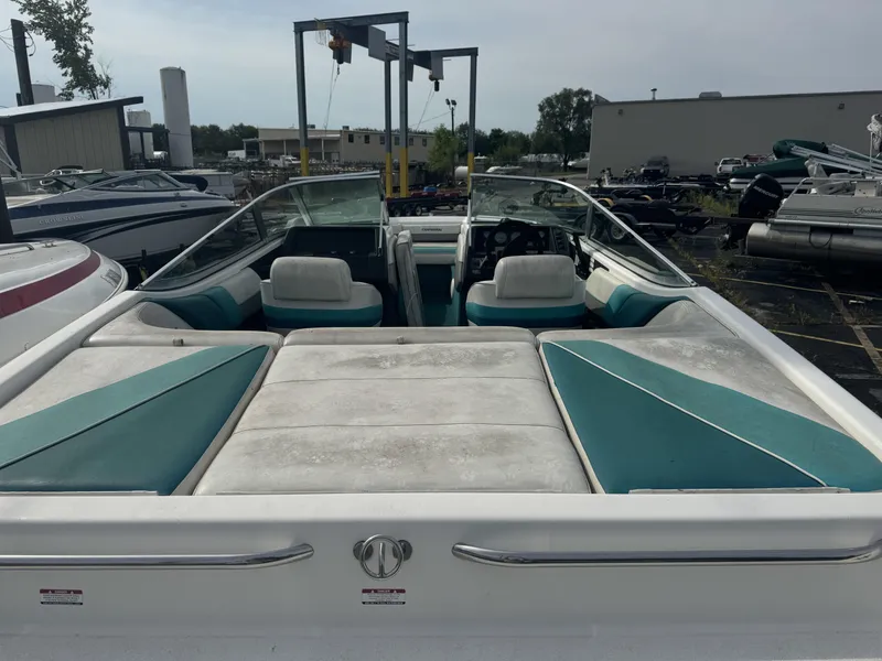 Slide: The Image of 1993 Chaparral 2000SL boat interior with teal and white seating, docked at a marina. - 3