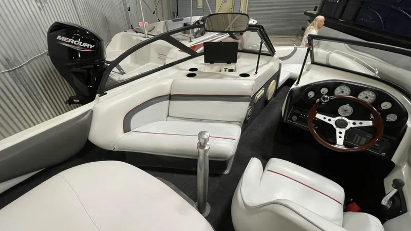 Slide: The Image of 1996 Tigé PRE2002WT boat interior with Mercury engine, white seating, and dashboard controls. - 8