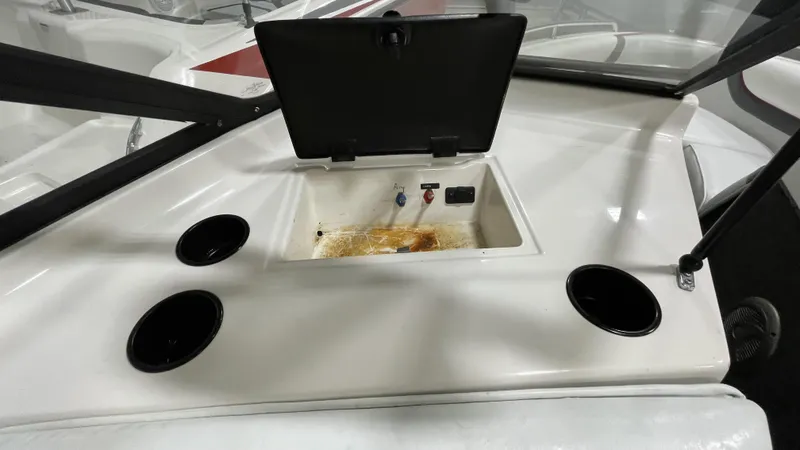 Slide: The Image of 1996 Tigé PRE2002WT boat dashboard with open storage compartment and cup holders. - 9