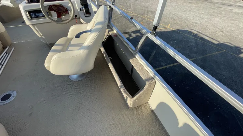Slide: The Image of 2007 Sun Tracker Fishing Deck 21 interior with beige seating and storage compartment. - 18