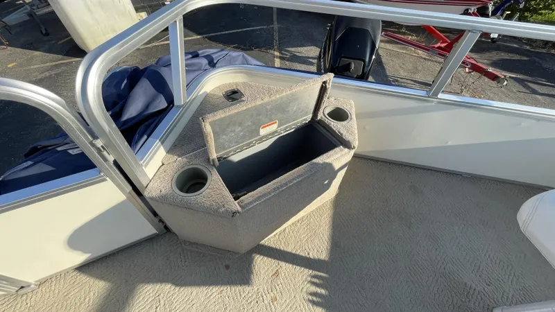 Slide: The Image of 2007 Sun Tracker Fishing Deck 21 boat interior with open storage compartment and cup holders. - 7