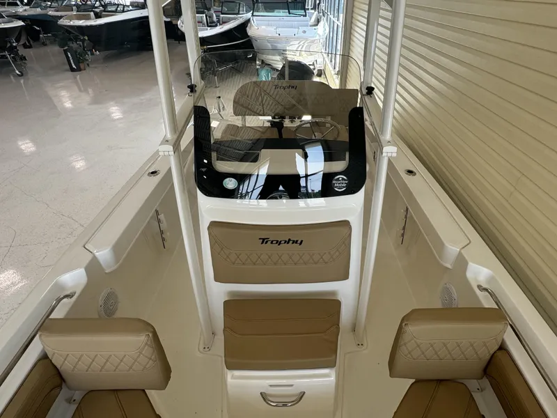 Slide: The Image of 2024 Bayliner TROPHY CC20 boat interior with tan cushioned seating and steering console. - 4