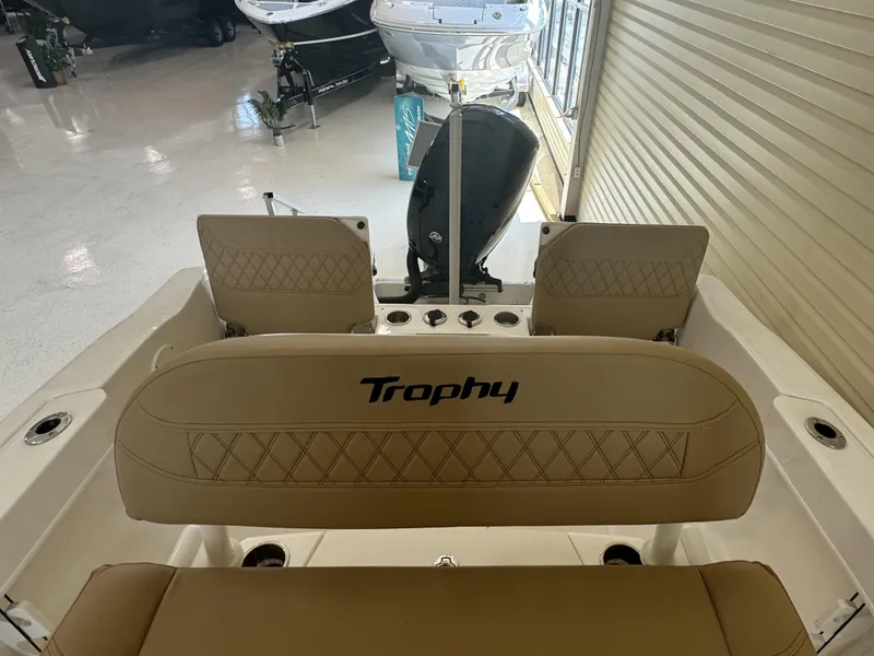 Slide: The Image of 2024 Bayliner TROPHY CC20 boat interior with tan seating and motor. - 5