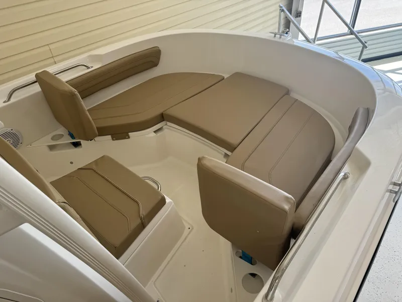 Slide: The Image of 2024 Bayliner TROPHY CC20 boat interior with tan cushioned seating. - 9