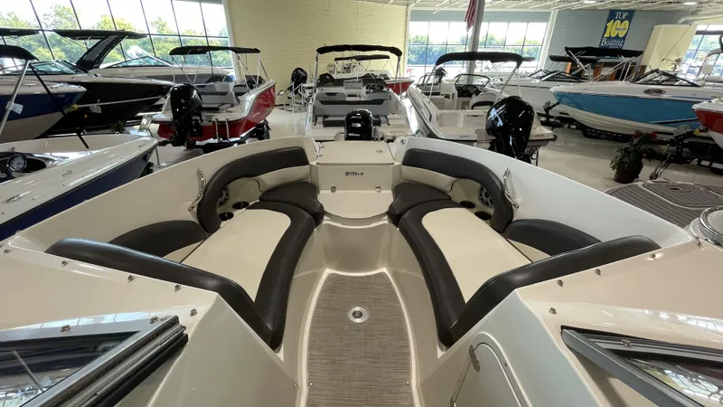 Slide: The Image of 2017 Stingray 215LR boat interior with spacious seating in a showroom. - 10
