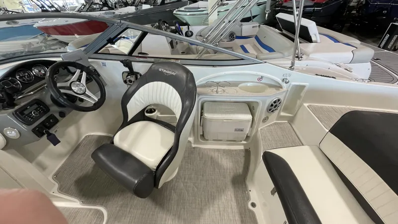 Slide: The Image of 2017 Stingray 215LR boat interior with steering wheel, seating, and storage. - 4