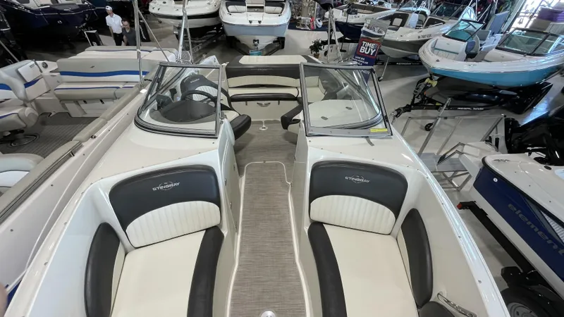 Slide: The Image of 2017 Stingray 215LR boat interior in showroom, featuring sleek seating and modern design. - 8