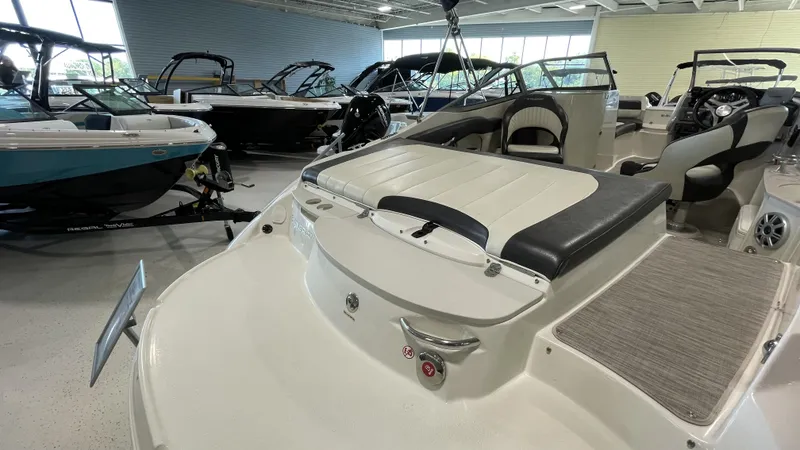 Slide: The Image of 2017 Stingray 215LR boat interior in showroom, featuring seating and control area. - 9