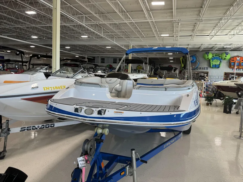 Slide: The Image of 2019 Starcraft Starstep 221 boat displayed in a showroom, featuring sleek design and seating. - 6