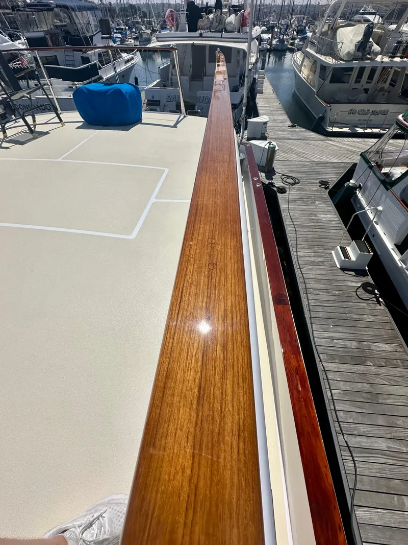 Slide: The Image of 1976 Ditmar & Donaldson Custom Yachtfisher with polished wood railing at marina. - 10