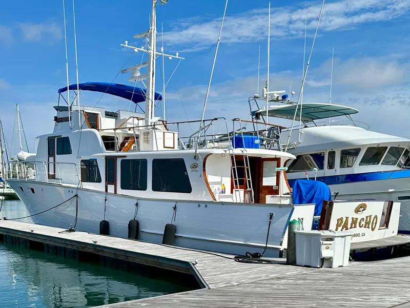 Slide: The Image of 1976 Ditmar & Donaldson Custom Yachtfisher docked at marina under clear blue sky. - 2