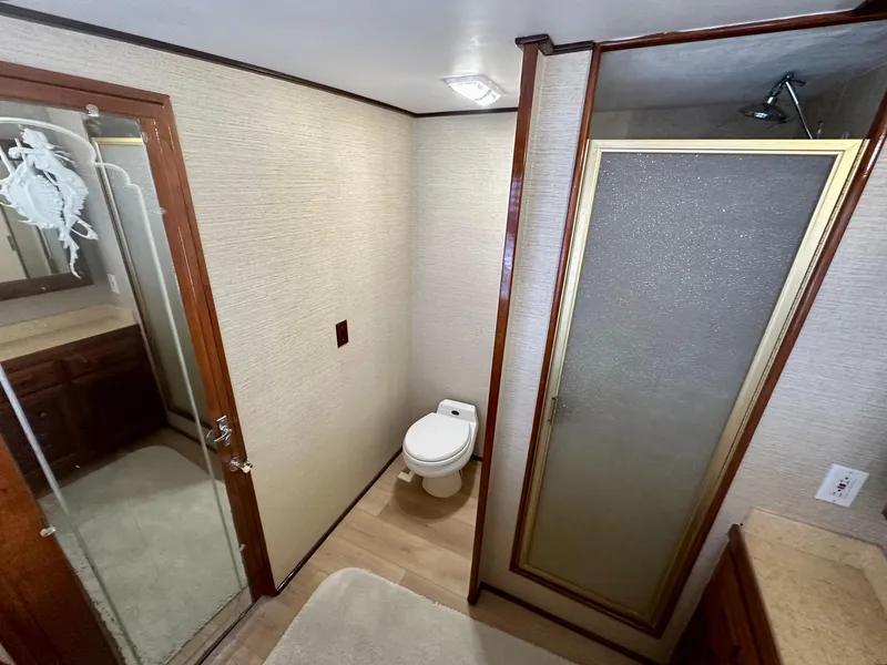 Slide: The Image of 1976 Ditmar & Donaldson Custom Yachtfisher bathroom with shower, toilet, and wooden accents. - 24