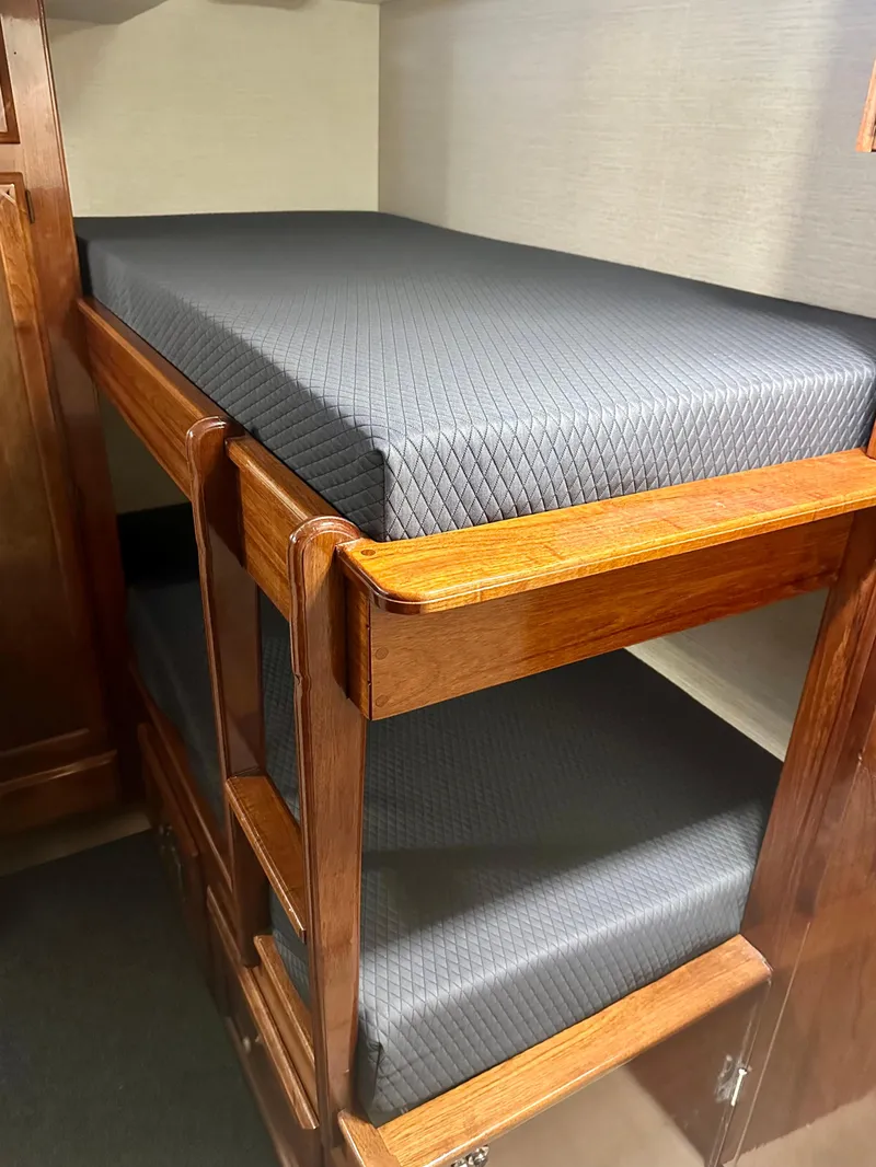 Slide: The Image of Bunk beds in 1976 Ditmar & Donaldson Custom Yachtfisher, featuring wooden frames and dark cushions. - 33