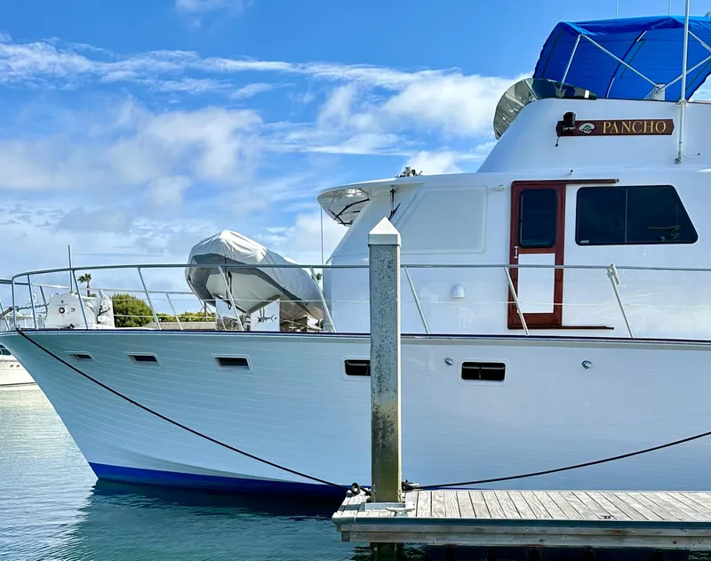 Slide: The Image of 1976 Ditmar & Donaldson Custom Yachtfisher docked, featuring sleek design and blue canopy. - 4