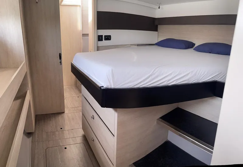 Slide: The Image of Modern bedroom interior of Leopard 50 yacht, 2020 model, featuring a raised bed and wooden cabinetry. - 14