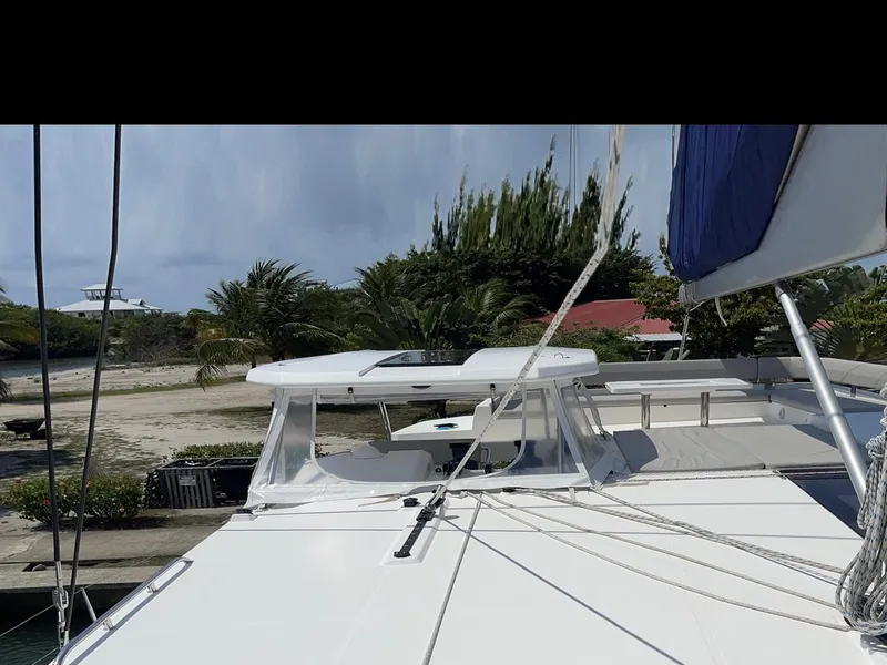 Slide: The Image of Leopard 50 catamaran, 2020 model, docked with lush greenery in the background. - 30