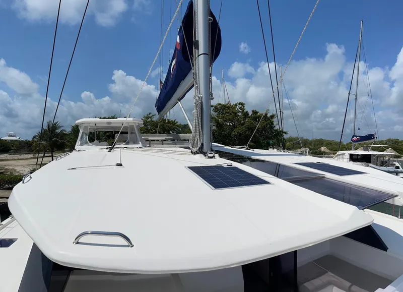 Slide: The Image of 2020 Leopard 50 catamaran with solar panels and sails, docked at a marina. - 34