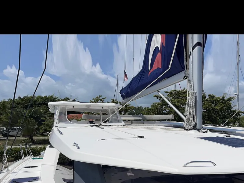 Slide: The Image of Leopard 50 catamaran, 2020 model, docked with sails up against a clear sky. - 35