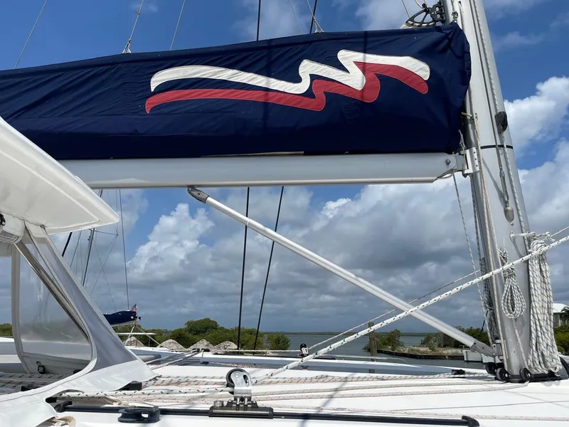 Slide: The Image of Leopard 50 sailboat, 2020 model, with blue sail cover and scenic ocean backdrop. - 36