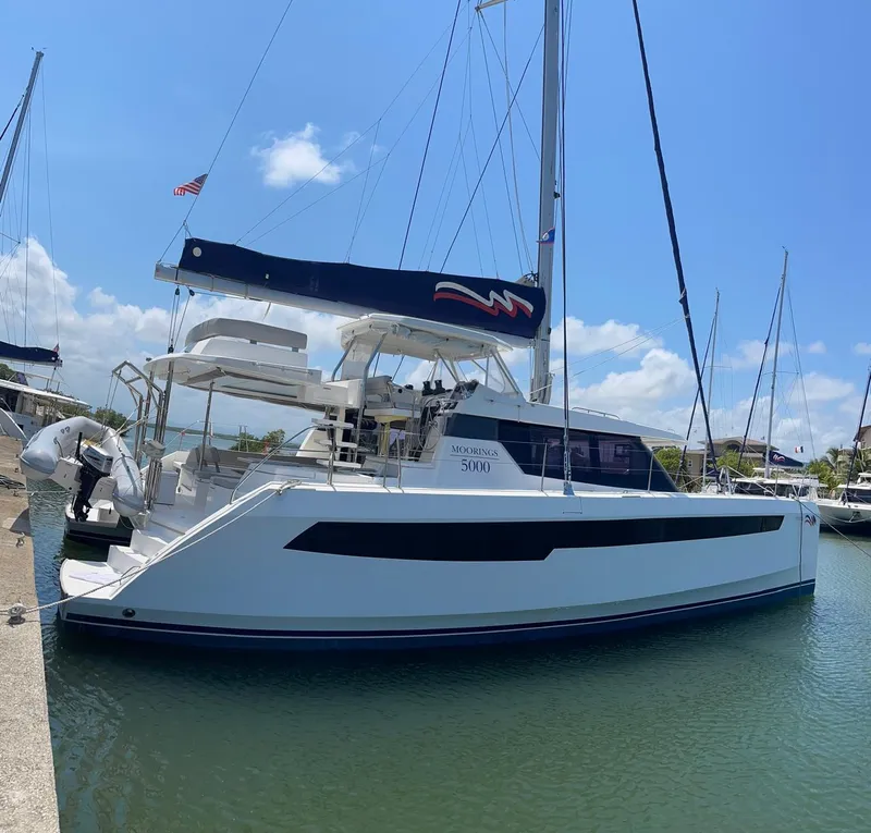 Slide: The Image of 2020 Leopard 50 catamaran docked at marina under clear blue sky. - 6