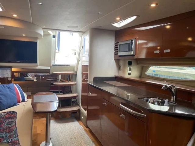 Slide: The Image of Interior of 2012 Sea Ray 370 Sundancer yacht with modern kitchen and cozy seating area. - 15