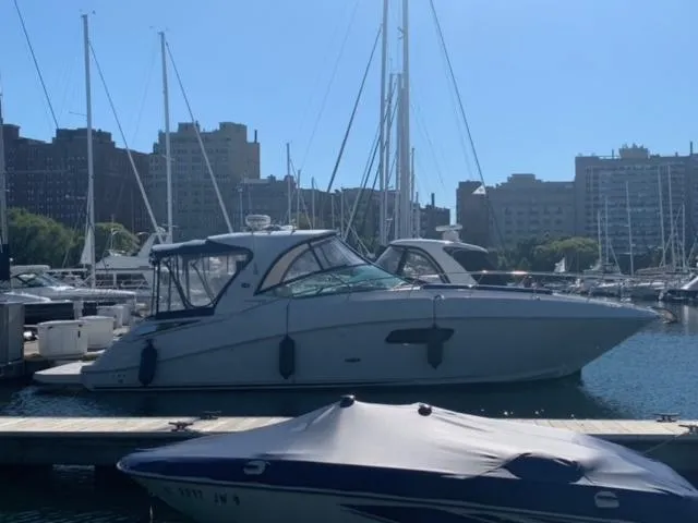 Slide: The Image of 2012 Sea Ray 370 Sundancer docked at a marina with city skyline in the background. - 16