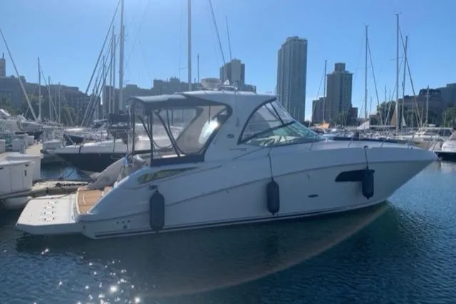 Slide: The Image of 2012 Sea Ray 370 Sundancer yacht docked in a marina with city skyline. - 22