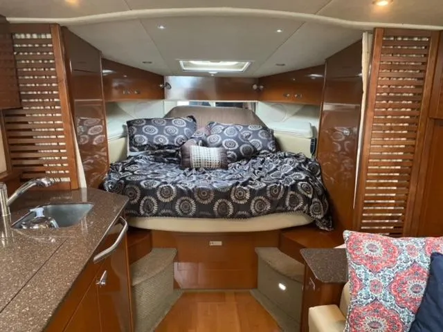Slide: The Image of Luxurious interior cabin of 2012 Sea Ray 370 Sundancer yacht with cozy bed and kitchenette. - 3