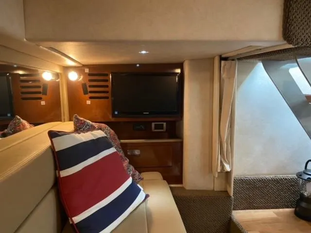 Slide: The Image of Interior of 2012 Sea Ray 370 Sundancer with TV, seating, and nautical decor. - 8