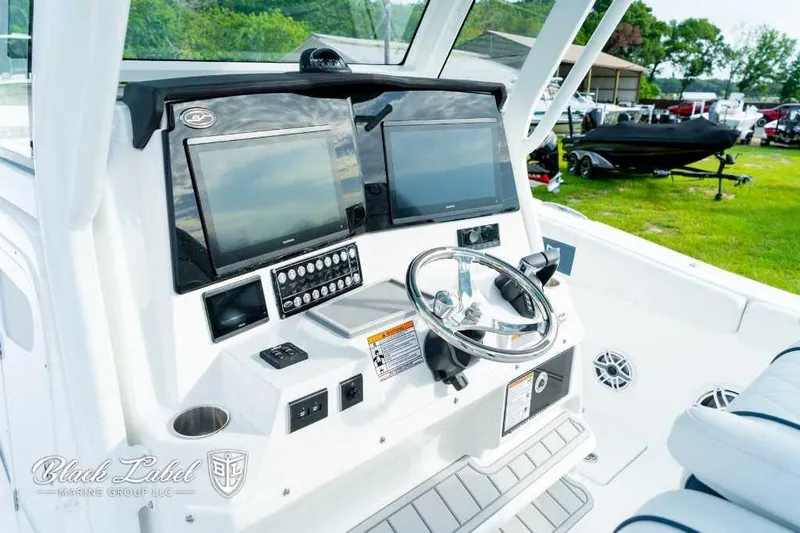 Slide: The Image of 2025 Sea Fox 328 Commander Center Console boat dashboard with dual screens and steering wheel. - 19