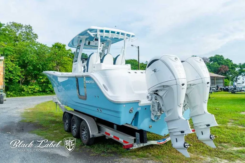 Slide: The Image of 2025 Sea Fox 328 Commander Center Console boat on trailer with twin Yamaha engines. - 2