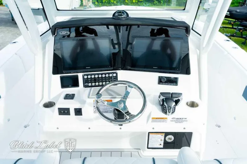 Slide: The Image of 2025 Sea Fox 328 Commander Center Console boat dashboard with dual screens and steering wheel. - 20
