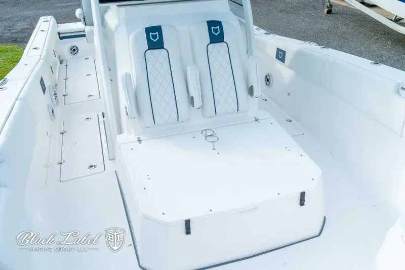 Slide: The Image of 2025 Sea Fox 328 Commander Center Console boat interior with white seating and storage compartments. - 8