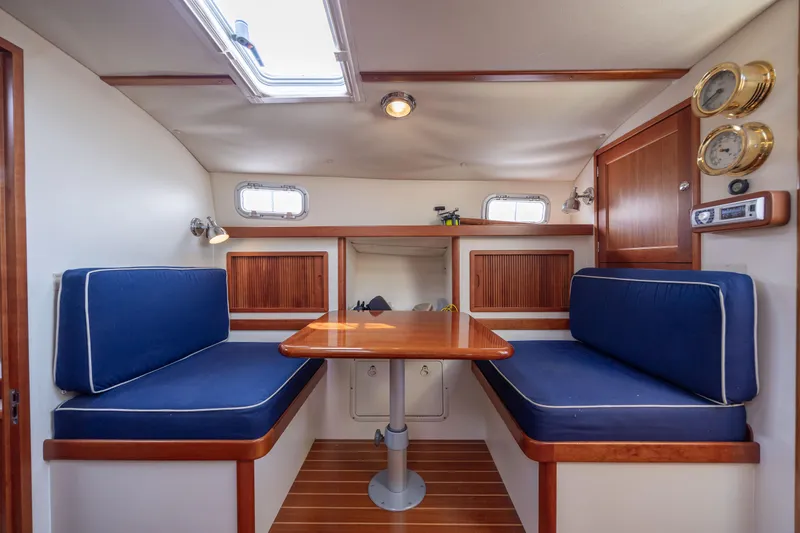Slide: The Image of Interior of 1998 Little Harbor WhisperJet 36 with blue cushioned seating and wooden table. - 25