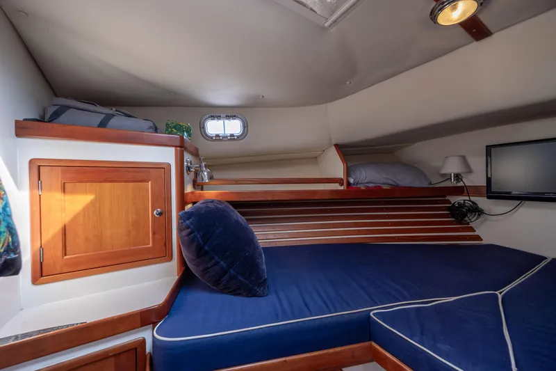 Slide: The Image of Cozy cabin interior of 1998 Little Harbor WhisperJet 36 with blue cushions and wooden accents. - 27