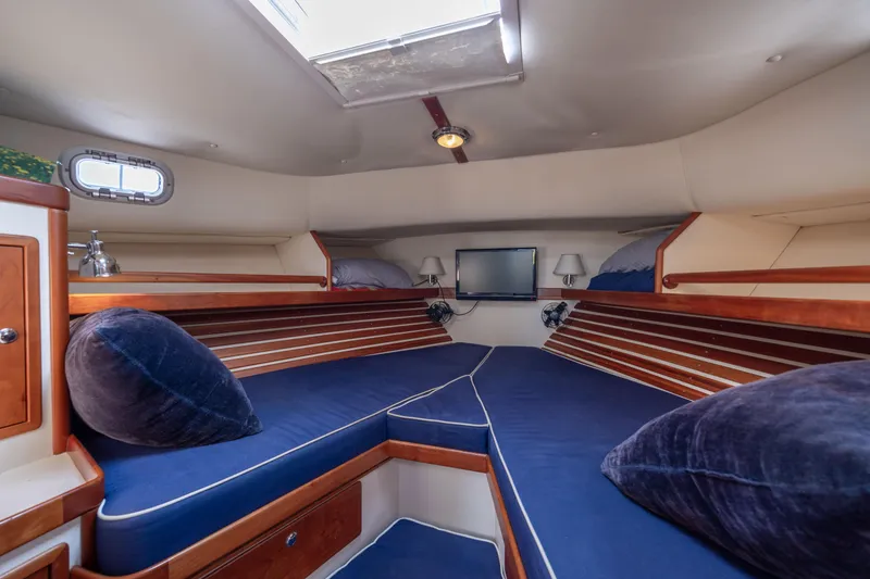 Slide: The Image of Interior cabin of 1998 Little Harbor WhisperJet 36 with blue cushions and wooden accents. - 28
