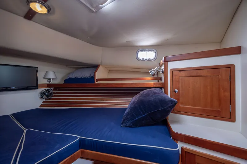 Slide: The Image of Interior cabin of 1998 Little Harbor WhisperJet 36 with blue cushions and wooden accents. - 29