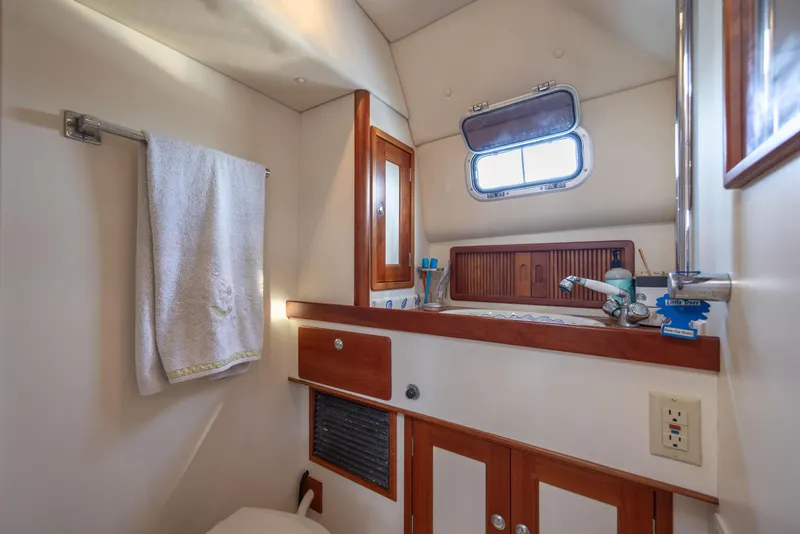 Slide: The Image of 1998 Little Harbor WhisperJet 36 bathroom with sink, towel rack, and storage cabinets. - 32